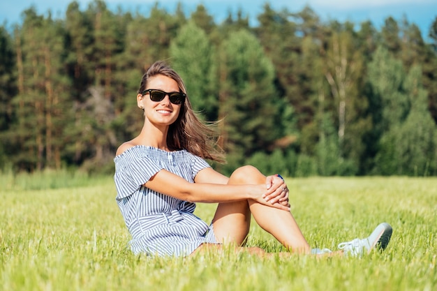 Photo woman wearing dress sitting on green grass field