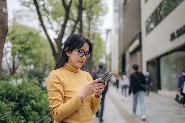 a woman wearing glasses is looking at her phone