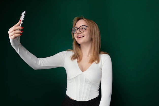 Woman wearing glasses taking picture with cell phone