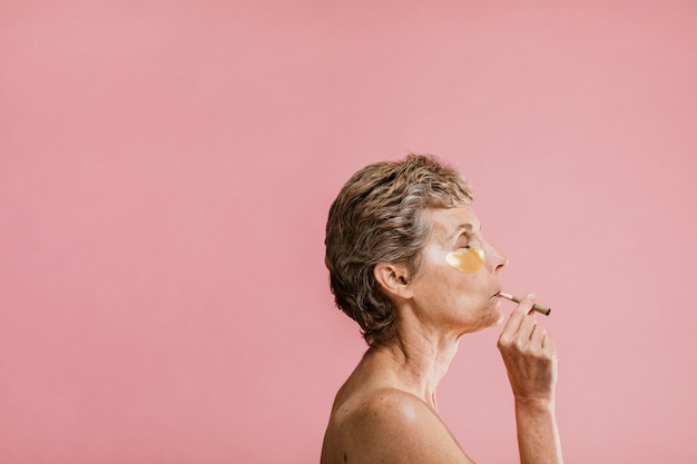 Woman wearing a golden eye mask and smoking cigars