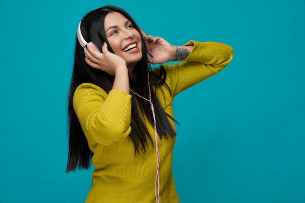 Woman wearing headphones, listening music and dancing