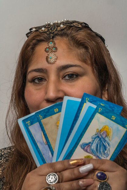 Woman wearing make up and jewelry showing tarot cards