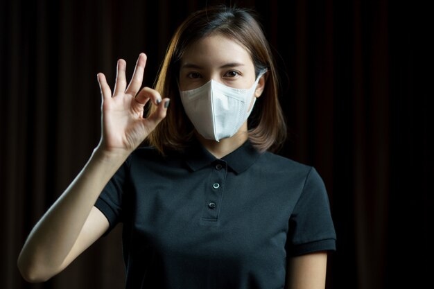 Woman wearing the N95 Respiratory protection mask showing hand ok sign.