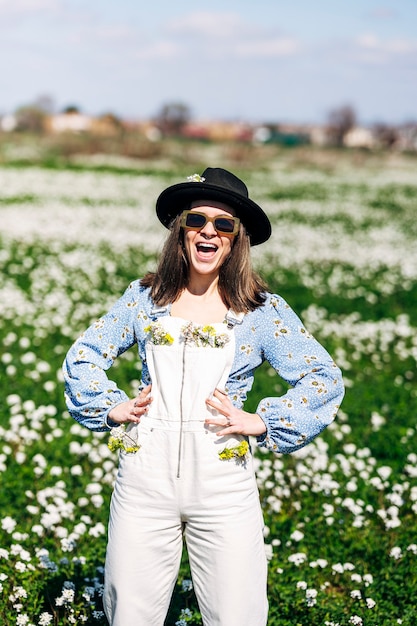 Woman wearing overalls with yellow and white flowers in pockets