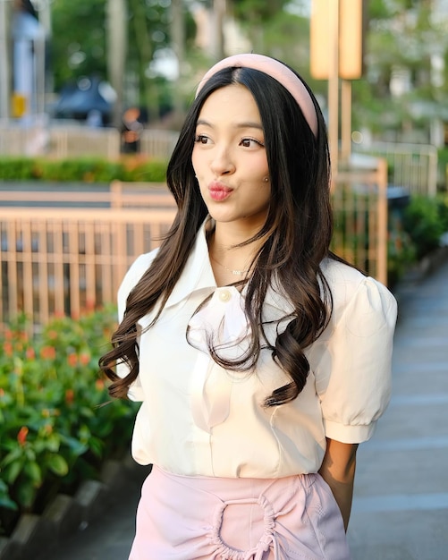 Photo a woman wearing a pink dress with a pink bow on her head