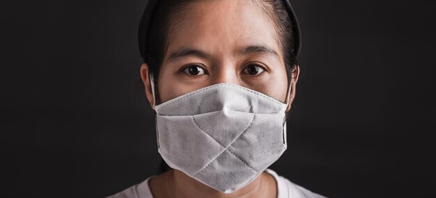 Woman wearing protective face mask with fear in her eyes