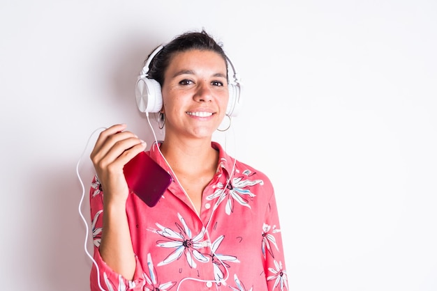 A woman wearing a red shirt with a floral wearing a headphone happy