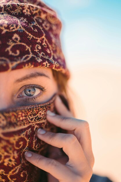 a woman wearing a scarf covering her eyes with a pattern on it