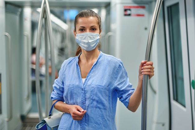 Woman wearing a surgical mask in the subway.