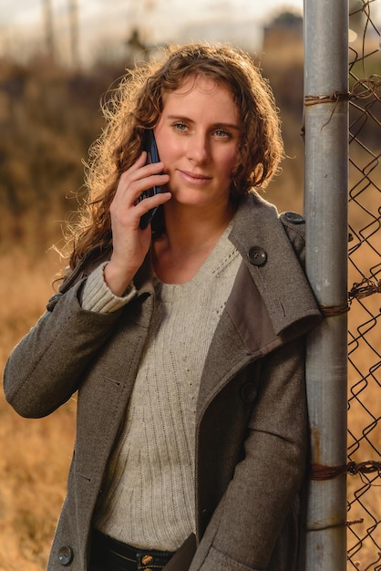 Woman wearing trendy clothes, walk the street  and uses her mobile phone to call, type or shopping