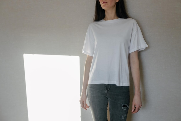 Woman wearing white blank t-shirt with space for your logo, mock up or design indoors