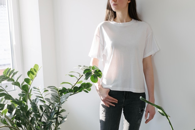 Woman wearing white blank t-shirt with space for your logo, mock up or design indoors