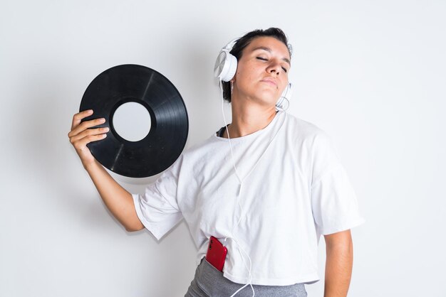 A woman wearing a white shirt with a record in her hand