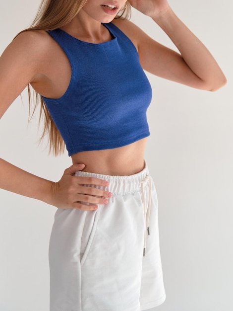 Photo woman wears blue crop top and white shorts copy space indoor lifestyle young girl