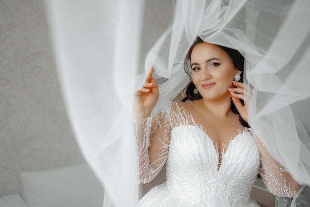 Photo a woman in a wedding dress is posing for a picture with her veil pulled back