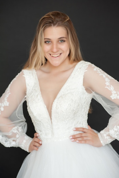 A woman in a wedding dress with a long sleeved top and a white dress with a long sleeves.