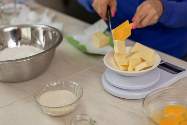 Woman weighing butter on a scale to prepare bread