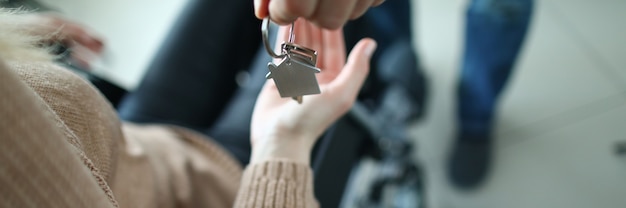 Photo woman in wheelchair is given keys to apartment