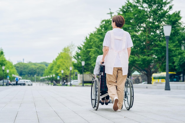 A woman in a wheelchair and a woman in an apron to care for