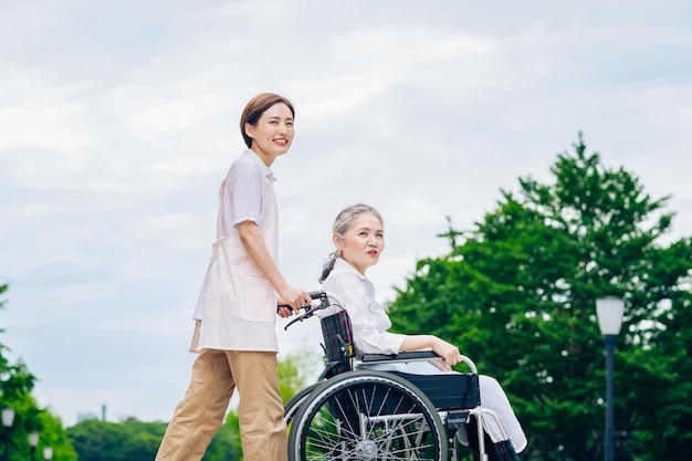 A woman in a wheelchair and young woman in an apron to care for