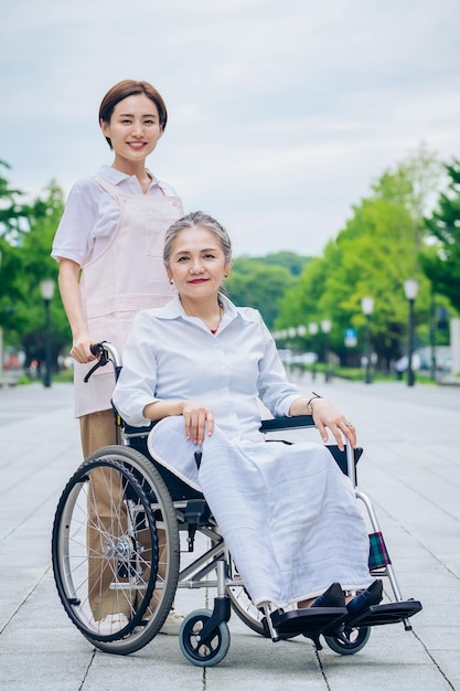 A woman in a wheelchair and young woman in an apron to care for