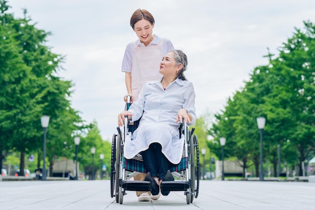 A woman in a wheelchair and young woman in an apron to care for