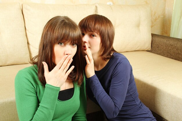 Photo woman whispers to the girlfriend secrets