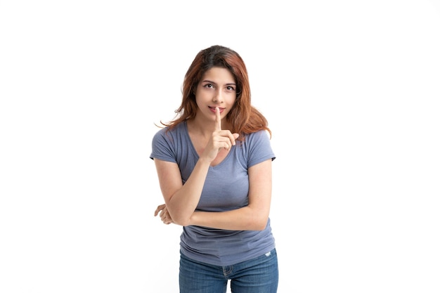 Woman on white background asking for silence with her finger