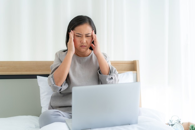 woman in white bed speaking with doctor using tele health technology