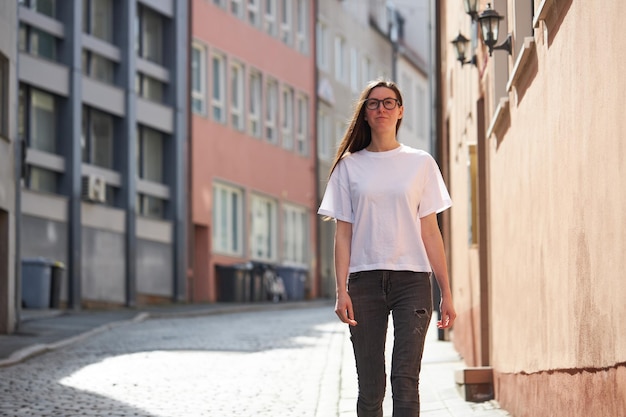 Woman in white blank tshirt wearing glasses in the city