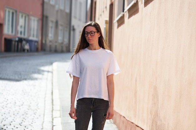 Woman in white blank tshirt wearing glasses in the city