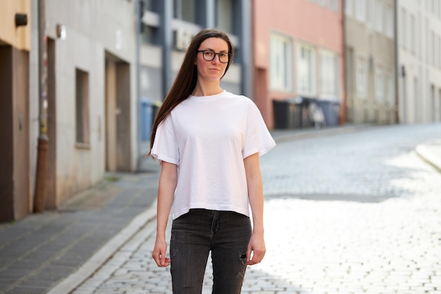 Woman in white blank tshirt wearing glasses in the city