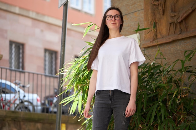 Woman in white blank tshirt wearing glasses in the city