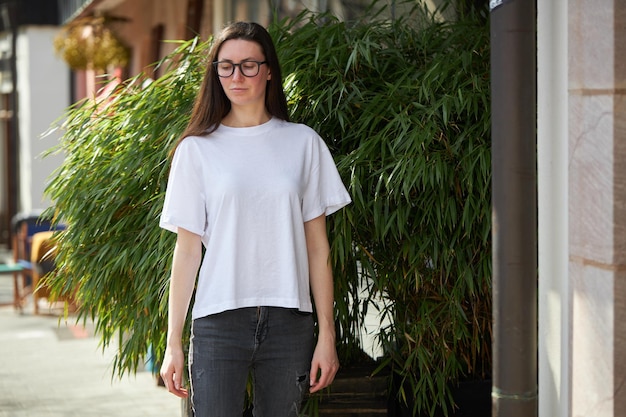 Woman in white blank tshirt wearing glasses in the city