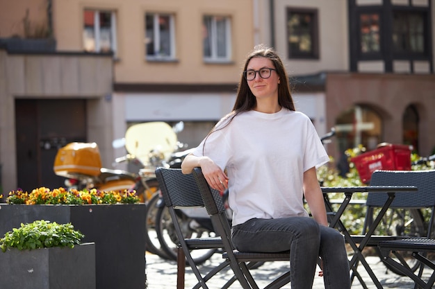 Woman in white blank tshirt wearing glasses in the city