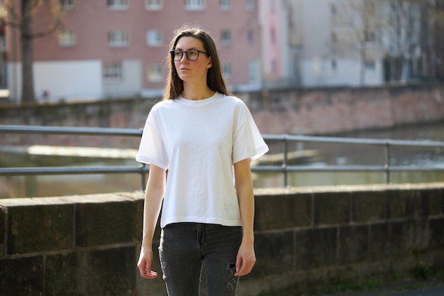 Woman in white blank tshirt wearing glasses in the city