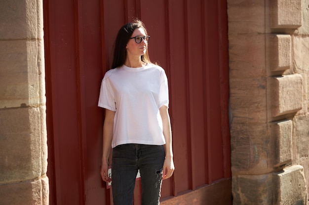 Woman in white blank tshirt wearing glasses in the city