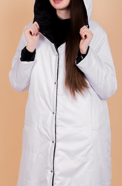 Woman in White Coat with Hood Peach Background