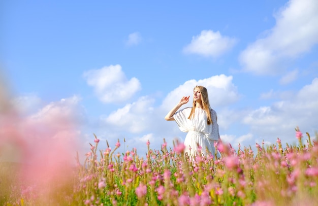 Woman in white dress on flowered sainfoin field woman on a blooming field of pink