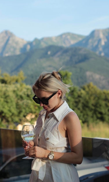 Photo a woman in a white dress holding a wine glass