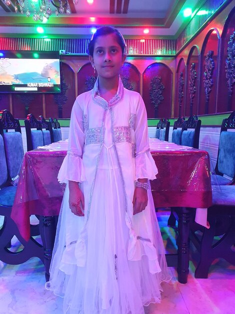 Photo woman in a white dress is standing in front of a colorful background