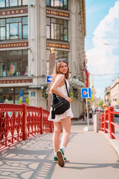 a woman in a white dress is walking on a bridge