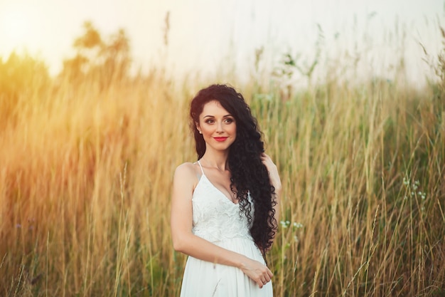 Woman in a white dress posing in a field