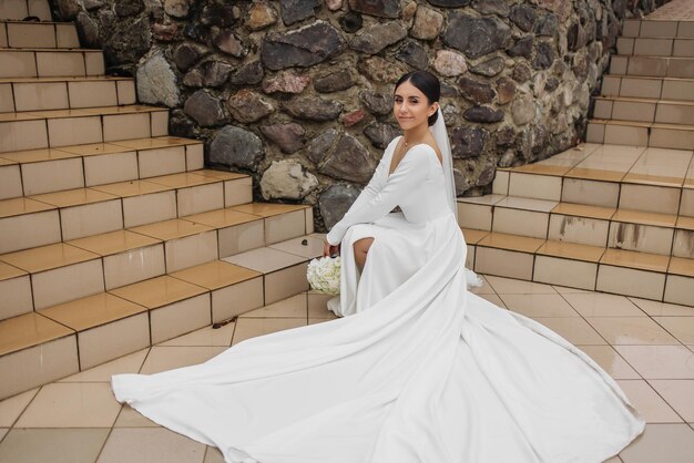 A woman in a white dress sits on a step