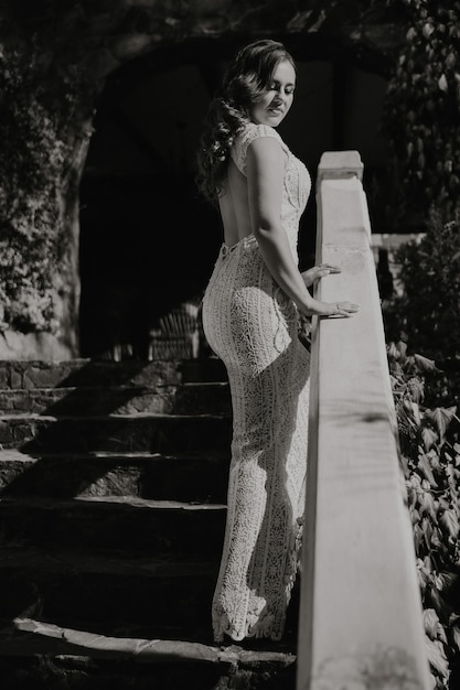 A woman in a white dress stands on a set of stairs