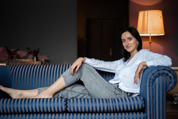 Woman in white shirt and jeans at home