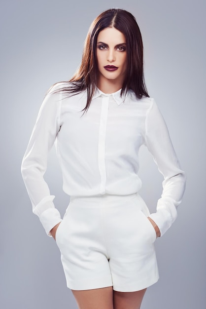 Woman in white Studio shot of a stylishly dressed young woman against a gray background