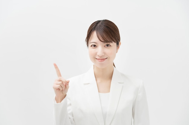 A woman in a white suit posing with her finger raised