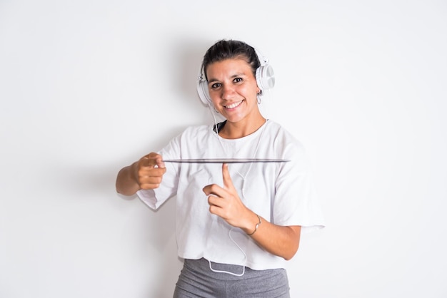 A woman in a white t - shirt holds a measuring device with her hands on a white background.