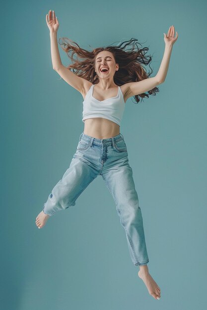 a woman in a white tank top is jumping in the air with her arms in the air